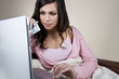A young woman holding a credit card and using a laptop
