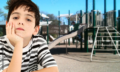 Photo: Handsome Young Boy Child Bored at Park. Handsome Young Boy Child Bored at Park.