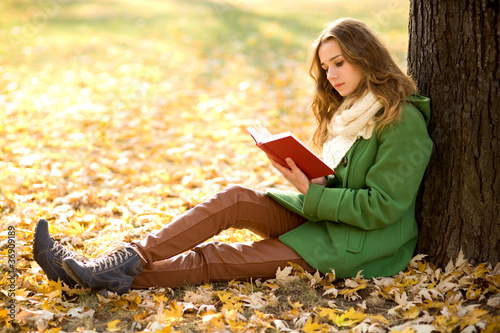 Photo: Girl reading book outdoors Girl reading book outdoors