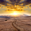 Mountain road on sunset background