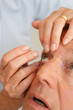 Woman helping man put in contact lenses