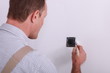 Man painting around a plug