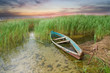 Wooden boat in cane on the bank of lake