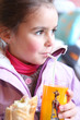 Little girl drinking orange juice through a straw