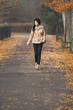 pretty young woman walking in autumn park