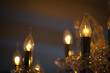 Close-up of the transparent lit bulbs of a crystal chandelier, s