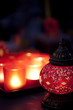 Red Arabian style candle holder with blurred red chandeliers in