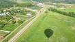 Hot air balloon cast shadow on village, view from gondola Hot air balloon cast shadow on village, view from gondola