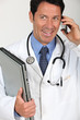 A doctor holding a laptop and having a conversation