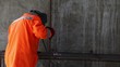 Worker in orange clothes weld metal gratings by acetylene torch