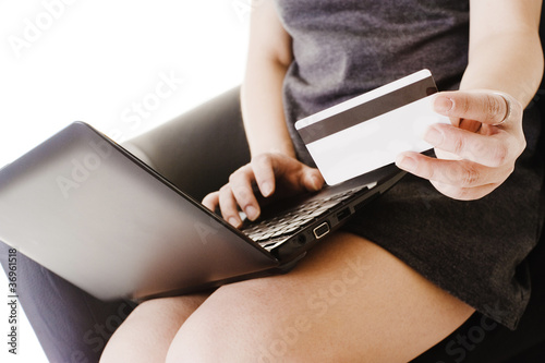 Photo: Chinese woman shopping online with a credit card. Chinese woman shopping online with a credit card.