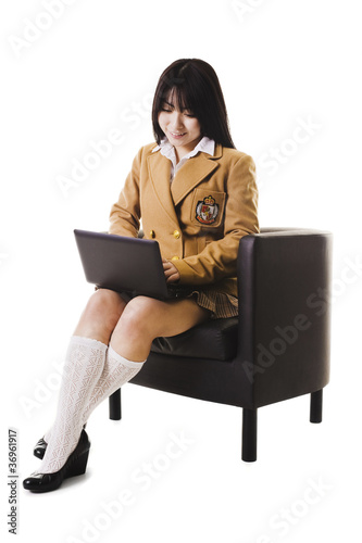 Photo: Chinese school girl working on a laptop. Chinese school girl working on a laptop.