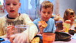 children sit around table, celebrating birthday party