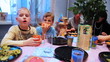 family and children sit around table, celebrating birthday party