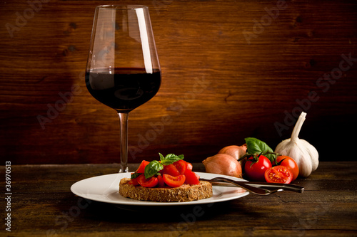 Photo: Bruschetta siciliana con vino su sfondo di legno Bruschetta siciliana con vino su sfondo di legno
