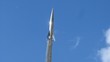 Monument to rocket on sky background