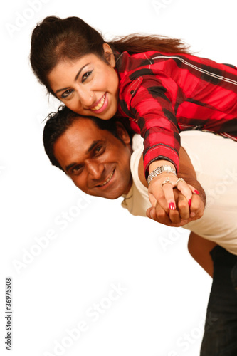 Foto: Smiling young Indian man piggybacking his pretty Wife Smiling young Indian man piggybacking his pretty Wife