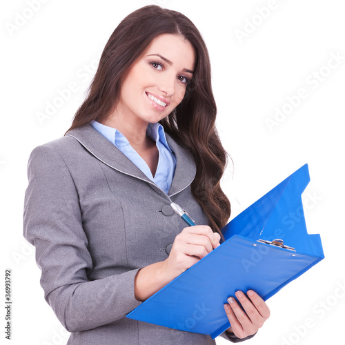 Photo: business woman writing on clipboard business woman writing on clipboard