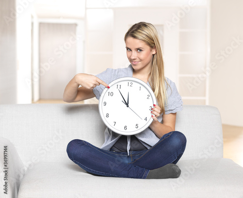 Photo: it's 5 before 12 - young woman pointing on clock / time it's 5 before 12 - young woman pointing on clock / time