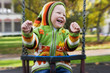 Boy playing on the swings at the playground