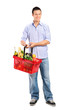 Portrait of a young male holding a full shopping basket