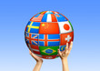 hands holding a sphere from flags