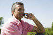 Man having conversation on cell phone, outdoors, smiling