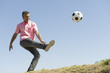 Man playing with soccer ball outdoors, smiling
