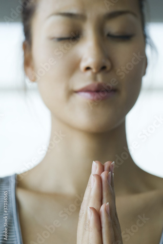 Foto: Young woman meditating in prayer position Young woman meditating in prayer position