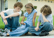 Children sitting in street, one with mp3 player
