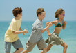 Three children racing on beach