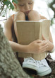 Girl in tree reading book