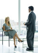 Businessman speaking to woman sitting in lobby