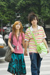 Young couple crossing street, holding hands, three quarter length