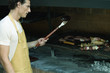Man grilling meat on barbecue