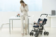 Professional woman in office with baby in stroller, talking on cell phone