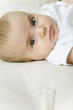 Baby lying on back, looking at camera, close-up