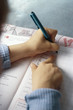 Child practicing handwriting in notebook, cropped