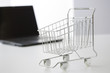 Foto: Miniature shopping cart and laptop computer Miniature shopping cart and laptop computer
