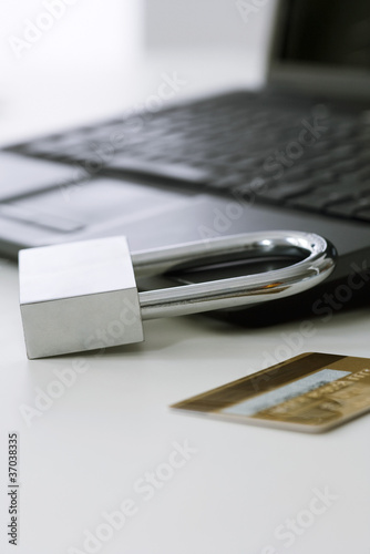 Photo: Padlock on laptop computer, credit card nearby Padlock on laptop computer, credit card nearby