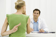 Female patient with hand behind back crossing fingers, speaking with doctor
