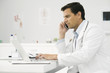 Doctor on phone call using laptop computer