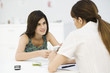 Teenage girl discussing birth control pills with gynecologist