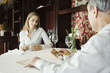 Mature couple having coffee in restaurant, man preparing to pay with credit card