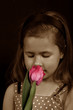 Foto: A small girl smelling a flower A small girl smelling a flower