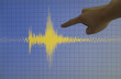Hand pointing a yellow earthquake with a blue background