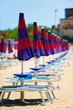 Sequence of parasols and beech chairs in Sicily