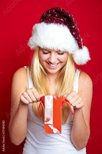 Foto: happy girl with christmas present and a hat happy girl with christmas present and a hat