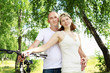 Photo: Young couple on the bikes in the park Young couple on the bikes in the park