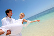 Groom holding bride in his arms by the sea